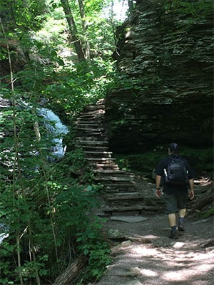 man hiking rickett's glen state park falls trail